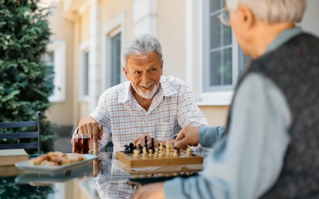 Senior men playing chess outside