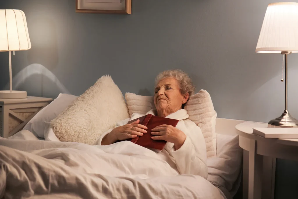 Senior woman in bed reading a book